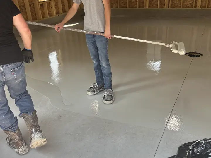 Rolling the clear topcoat across a freshly coated floor